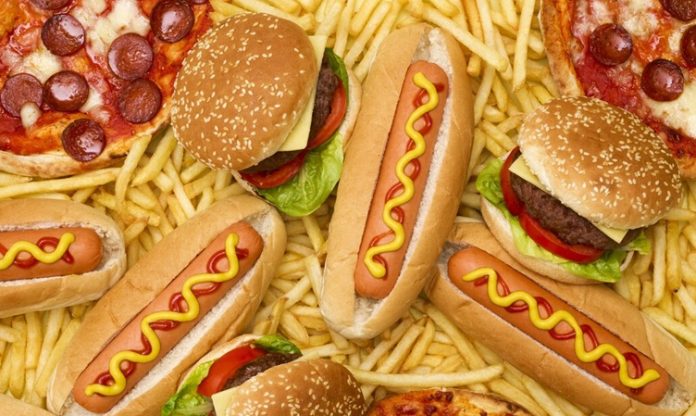 Günümüz şehir yaşamının yoğun temposu, yemek alışkanlıklarını da önemli ölçüde etkiledi. Fast food kültürü, hız ve pratiklik arayanların vazgeçilmez tercihlerinden biri haline geldi. Hamburgerden pizzaya, tavuk kanadından sandviçe kadar uzanan geniş bir yelpazede sunulan bu lezzetler, özellikle gençler arasında büyük ilgi görüyor. Konulu bir haber görseli.