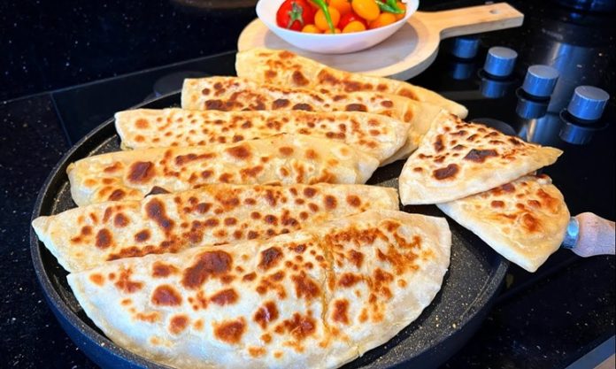 Gözleme, Türk mutfağının yüzyıllardır süregelen hamur işi lezzetlerinden biridir. Anadolu’nun her köşesinde farklı tariflerle hazırlanabilen gözleme, hem pratik hem de doyurucu oluşuyla bilinir. Geleneksel tariflerde kullanılan un ve su ile hazırlanan hamur, ince açılır ve çeşitli iç malzemelerle doldurulur. Konulu bir haber görseli.
