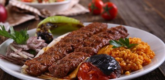 Kebabın Farklı Yüzleri Anadolu’dan Dünyaya Açılan Ateşin Hikâyesi Kebap, Türk mutfağının en köklü ve en tanınan lezzetlerinden biri olarak, yalnızca bir yemek değil aynı zamanda bir yaşam biçimi olarak da değerlendirilebilir. Etin ateşle buluştuğu bu eşsiz teknik, binlerce yıllık geçmişe sahiptir ve tarih boyunca birçok uygarlığın mutfağında kendine yer bulmuştur. Ancak Anadolu toprakları, kebap kültürünü sadece korumakla kalmamış, aynı zamanda onu çeşitlendirip zenginleştirmiştir. Konulu bir haber görseli.