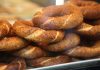 Simit, Osmanlı döneminden günümüze kadar gelen köklü bir geçmişe sahiptir. İlk olarak saray mutfaklarında farklı un karışımlarıyla yapılan bu lezzet, zamanla halk arasında yaygınlaşarak günlük yaşamın bir parçası haline gelmiştir. Özellikle 16. yüzyıldan itibaren İstanbul’da simit fırınlarının açılmasıyla birlikte, bu eşsiz yiyecek şehir kültürünün önemli bir unsuru olmuştur.