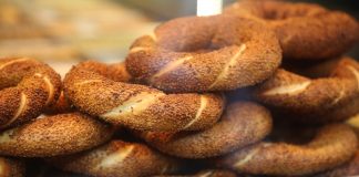 Simit, Osmanlı döneminden günümüze kadar gelen köklü bir geçmişe sahiptir. İlk olarak saray mutfaklarında farklı un karışımlarıyla yapılan bu lezzet, zamanla halk arasında yaygınlaşarak günlük yaşamın bir parçası haline gelmiştir. Özellikle 16. yüzyıldan itibaren İstanbul’da simit fırınlarının açılmasıyla birlikte, bu eşsiz yiyecek şehir kültürünün önemli bir unsuru olmuştur.
