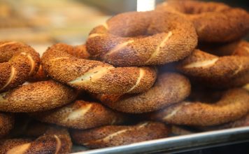 Simit Türk Kültürünün Vazgeçilmez Lezzeti Simit, Osmanlı döneminden günümüze kadar gelen köklü bir geçmişe sahiptir. İlk olarak saray mutfaklarında farklı un karışımlarıyla yapılan bu lezzet, zamanla halk arasında yaygınlaşarak günlük yaşamın bir parçası haline gelmiştir. Özellikle 16. yüzyıldan itibaren İstanbul’da simit fırınlarının açılmasıyla birlikte, bu eşsiz yiyecek şehir kültürünün önemli bir unsuru olmuştur.