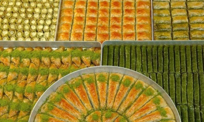 Türk mutfağının en ünlü tatlılarından biri olan baklava, sofralarda özel bir yere sahiptir. İnce açılmış hamur katmanları, bol ceviz veya fıstık içi ve şerbetin muhteşem uyumu, baklavayı hem gözlere hem de damaklara hitap eden bir tatlı haline getirir. Baklava, sadece Türkiye’de değil, dünya genelinde de sevilen ve takdir edilen bir lezzettir. Sofralarda baklava ve diğer tatlılar, kutlamaların, özel günlerin ve misafirliklerin vazgeçilmez unsurlarındandır. Konulu bir haber görseli.