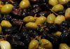Zeytin, Akdeniz mutfağının en önemli ve en eski besinlerinden biri olarak sofralarda vazgeçilmez bir yer tutar. Hem sofralık olarak hem de zeytinyağı yapımında kullanılan zeytin, çeşitliliğiyle de dikkat çeker. Türkiye’de özellikle Ege, Marmara ve Akdeniz bölgelerinde yetişen birçok zeytin türü bulunur. Sofralarda zeytin çeşitleri, farklı tat ve aromalarıyla hem damak tadını zenginleştirir hem de kültürel bir miras olarak nesilden nesile aktarılır. Konulu bir haber görseli.