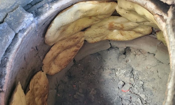 Tandır ekmeği, yüzyıllardır Türk mutfağının vazgeçilmez unsurlarından biridir. Bu özel ekmek, özellikle Anadolu’nun kırsal bölgelerinde taş fırın veya tandırda pişirilerek sofralara gelir. Tarih boyunca, köy ve kasaba mutfaklarının olmazsa olmazı olan tandır ekmeği, hem lezzeti hem de kendine has aromasıyla tanınır. Konulu bir haber görseli.