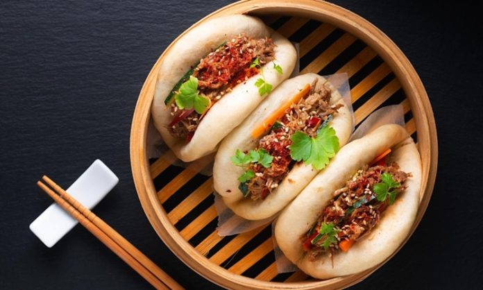 Bao Bun, Çin mutfağının en sevilen hamur işleri arasında yer alır. Yumuşacık dokusu ve farklı iç malzemeleriyle dikkat çeken bu lezzet, özellikle Uzak Doğu mutfağına meraklı olanların ilgisini çeker. Geleneksel olarak buharda pişirilen hamurdan yapılan Bao Bun, iç harcına göre etli, sebzeli veya tatlı alternatiflerle hazırlanabilir. Kökeni Çin’in kuzey bölgelerine dayanan bu yiyecek, yüzyıllar boyunca hem halk sofralarında hem de özel günlerde kendine yer bulmuştur. Konulu bir haber görseli.