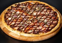 Barbekü pizza, klasik İtalyan pizzalarının modern yorumlarından biri olarak öne çıkar. Barbekü sosu kullanımı, pizzaya özgün bir tat ve aroma katarak farklı bir lezzet deneyimi sunar. İlk olarak Amerika’da ortaya çıkan barbekü pizzası, kısa sürede dünya genelinde popülerlik kazanmıştır. Konulu bir haber görseli.