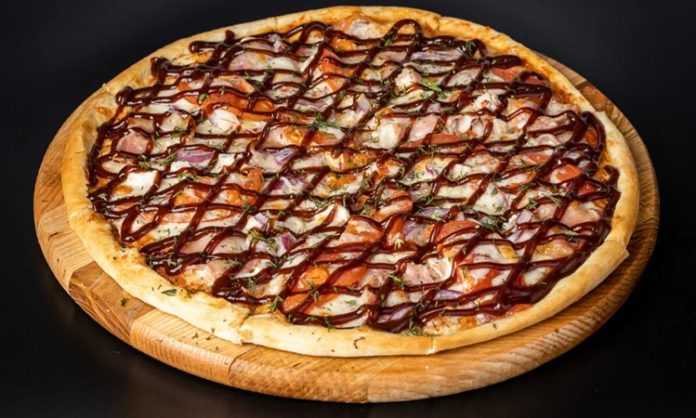 Barbekü pizza, klasik İtalyan pizzalarının modern yorumlarından biri olarak öne çıkar. Barbekü sosu kullanımı, pizzaya özgün bir tat ve aroma katarak farklı bir lezzet deneyimi sunar. İlk olarak Amerika’da ortaya çıkan barbekü pizzası, kısa sürede dünya genelinde popülerlik kazanmıştır. Konulu bir haber görseli.