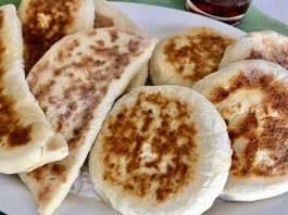 Bazlama: Gelenekten Sofralara Uzanan Sıcak Lezzet Türk mutfağının en özel ve sevilen ekmek çeşitlerinden biri olan bazlama, yumuşak dokusu, doyurucu yapısı ve mis gibi kokusuyla sofraların vazgeçilmezidir. Özellikle Anadolu’nun birçok bölgesinde kahvaltıların, çay saatlerinin ve hatta ana yemeklerin yanında sıklıkla tercih edilen bu ekmek, sadece lezzetiyle değil kültürel bir değer olarak da öne çıkar. Günümüzde modern sofralarda da kendine yer bulan bazlama, hem geleneksel hem de pratik bir lezzet olarak dikkat çekmektedir. Konulu bir haber görseli.
