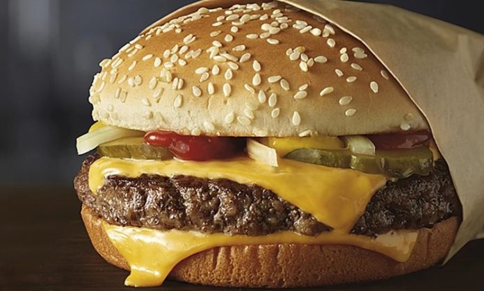 Cheeseburger, adını aldığı peynirle birleşerek hamburgerin en sevilen versiyonlarından biri olmuştur. İlk olarak 1920’lerde Amerika’da ortaya çıktığı bilinen cheeseburger, kısa sürede tüm dünyaya yayılarak milyonların vazgeçilmez lezzeti haline gelmiştir. Hamburgerin köfte ve ekmekten oluşan temel yapısına eriyen peynirin eklenmesiyle doğan bu tarif, damakta farklı bir tat yaratmıştır. Konulu bir haber görseli.
