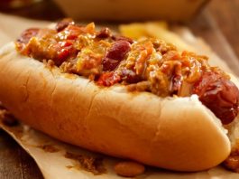 Chili Dog: Sokak Lezzetlerinin Baharatlı Yıldızı Amerika mutfağının en sevilen sokak lezzetlerinden biri olan chili dog, klasik hot dog’un baharatlı bir versiyonudur. Kökeni 20. yüzyılın başlarına uzanan bu yiyecek, özellikle Teksas ve Kaliforniya sokaklarında popüler hale gelmiştir. Klasik sosis ve ekmek kombinasyonunun üzerine eklenen acılı chili sos, chili dog’un karakteristik özelliğini oluşturur. Konulu bir haber görseli.