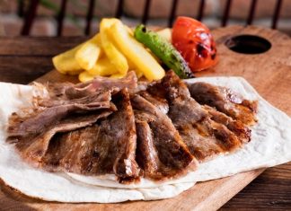 Et Döner: Lezzetiyle Türk Mutfağının Vazgeçilmez Lezzeti Türk mutfağının en önemli lezzetlerinden biri olan et döner, tarihsel olarak Osmanlı döneminden günümüze kadar uzanan bir yolculuğa sahiptir. Yatay şişlerde pişirilen etlerin zamanla dikey şişlere geçirilmesiyle ortaya çıkan bu yöntem, özellikle hızlı servis imkânı ve eşsiz lezzetiyle kısa sürede halkın gözdesi haline gelmiştir. Dönerin geçmişi, yalnızca bir yemeğin tarihi değil, aynı zamanda Anadolu’nun kültürel çeşitliliğinin de bir yansımasıdır. Konulu bir haber görseli.