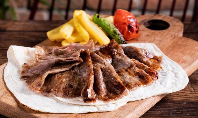 Türk mutfağının en önemli lezzetlerinden biri olan et döner, tarihsel olarak Osmanlı döneminden günümüze kadar uzanan bir yolculuğa sahiptir. Yatay şişlerde pişirilen etlerin zamanla dikey şişlere geçirilmesiyle ortaya çıkan bu yöntem, özellikle hızlı servis imkânı ve eşsiz lezzetiyle kısa sürede halkın gözdesi haline gelmiştir. Dönerin geçmişi, yalnızca bir yemeğin tarihi değil, aynı zamanda Anadolu’nun kültürel çeşitliliğinin de bir yansımasıdır. Konulu bir haber görseli.
