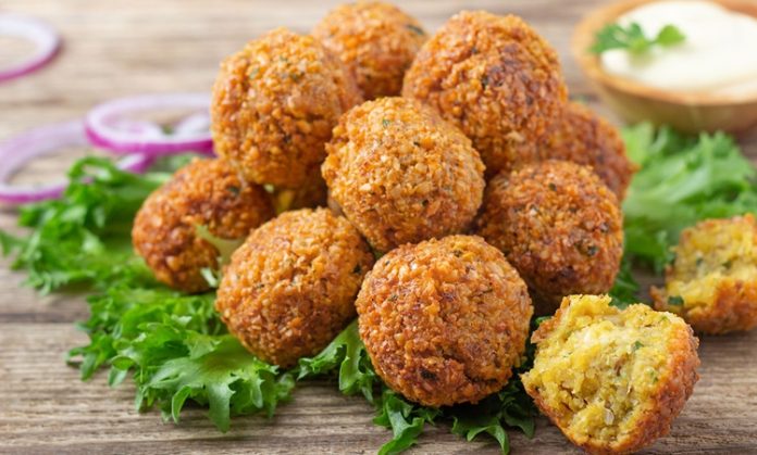 Falafel, Orta Doğu mutfağının en bilinen ve sevilen lezzetlerinden biridir. Nohut veya bakla bazlı olarak hazırlanan bu kızartılmış toplar, hem vejetaryenler hem de et severler için sağlıklı bir alternatif sunar. Baharatlar ve taze otlarla zenginleştirilen falafel, çıtır dış yüzeyi ve yumuşak iç dokusuyla damaklarda unutulmaz bir tat bırakır. Bu yazımızda falafel tarifinden tarihçesine, hazırlık aşamalarından sunum önerilerine kadar detaylı bilgiler bulabilirsiniz. Konulu bir haber görseli.