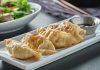 Gyoza, Japon mutfağının en sevilen yemeklerinden biridir ve kökeni Çin’e dayanmaktadır. Aslında Çin’deki jiaozi adı verilen hamur işinden esinlenerek Japonya’ya taşınmış ve zamanla farklı bir kimlik kazanmıştır. Japon mutfağına özgü pişirme teknikleri, gyozayı benzersiz bir hale getirmiştir. Bugün hem Japonya’da hem de dünyanın birçok ülkesinde gyoza, restoranların ve ev sofralarının vazgeçilmez lezzetleri arasında yer almaktadır. Konulu bir haber görseli.