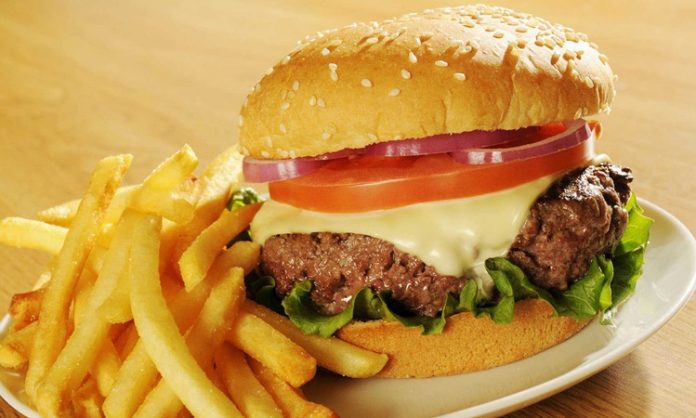 Hamburger, günümüzde hızlı yemek kültürünün en bilinen simgelerinden biridir. Ancak bu lezzetin kökenleri çok daha eskilere dayanır. Almanya’nın Hamburg şehrinden adını alan hamburger, Amerika’da popülerleşmiş ve kısa sürede küresel bir fenomen haline gelmiştir. Bugün dünyanın neredeyse her köşesinde farklı çeşitleriyle tüketilen hamburger, yalnızca bir yiyecek değil aynı zamanda modern yaşamın simgelerinden biri olmuştur. Konulu bir haber görseli.