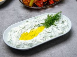Haydari, özellikle kahvaltı sofralarının ve mezelerin vazgeçilmez tatlarından biridir. Yoğurt bazlı bu lezzetli meze, hem hafif hem de besleyici olmasıyla öne çıkar. Haydari, yüksek protein içeriği sayesinde kas ve kemik sağlığını desteklerken, probiyotik özelliği ile sindirim sistemine katkıda bulunur. İçerdiği sarımsak ve dereotu gibi doğal malzemeler, lezzetin yanı sıra sağlık açısından da avantaj sağlar. Konulu bir haber görseli.