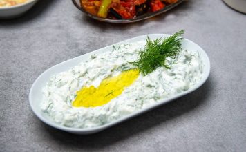 Haydari İle Sofralara Ferahlık Katın Haydari, özellikle kahvaltı sofralarının ve mezelerin vazgeçilmez tatlarından biridir. Yoğurt bazlı bu lezzetli meze, hem hafif hem de besleyici olmasıyla öne çıkar. Haydari, yüksek protein içeriği sayesinde kas ve kemik sağlığını desteklerken, probiyotik özelliği ile sindirim sistemine katkıda bulunur. İçerdiği sarımsak ve dereotu gibi doğal malzemeler, lezzetin yanı sıra sağlık açısından da avantaj sağlar. Konulu bir haber görseli.