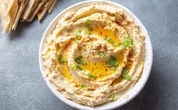 Humus: Lezzetiyle Sofraların Vazgeçilmez Mezesi Humus, Orta Doğu mutfağının en bilinen ve sevilen mezelerinden biridir. Başlıca malzemeleri nohut, tahin, limon suyu, sarımsak ve zeytinyağı olan bu özel tarif, yüzyıllardır sofralarda yerini almaktadır. Tarihi çok eski dönemlere dayanan humus, özellikle Lübnan, Suriye, Filistin ve Türkiye gibi bölgelerde yaygın olarak tüketilir. Bugün ise dünya genelinde sağlıklı bir atıştırmalık ya da ana yemek yanında tamamlayıcı olarak tercih edilmektedir. Konulu bir haber görseli.