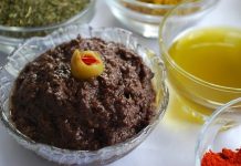 Zeytin ezmesi, yüzyıllardır özellikle Akdeniz mutfak kültüründe kendine özel bir yer edinmiş sağlıklı bir lezzettir. Anadolu’da kahvaltı sofralarının vazgeçilmezi olarak bilinen bu eşsiz tat, sadece kahvaltılarda değil farklı yemeklerin yanında da tüketilmektedir. Zeytin ağacının binlerce yıllık geçmişi, bu ürünü adeta bir kültürel miras haline getirmiştir. Bu nedenle, özellikle köylerde yapılan doğal yöntemlerle hazırlanmış zeytin ezmesi, sofralarda hem lezzeti hem de sağlık açısından sunduğu faydalar ile tercih edilmektedir. Konulu bir haber görseli.