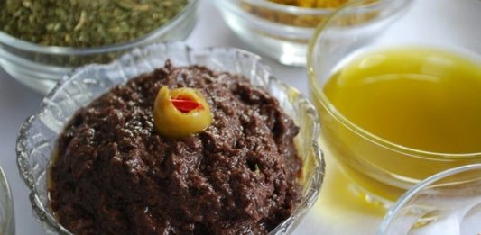 Kahvaltı Sofralarının Vazgeçilmezi Zeytin Ezmesi Zeytin ezmesi, yüzyıllardır özellikle Akdeniz mutfak kültüründe kendine özel bir yer edinmiş sağlıklı bir lezzettir. Anadolu’da kahvaltı sofralarının vazgeçilmezi olarak bilinen bu eşsiz tat, sadece kahvaltılarda değil farklı yemeklerin yanında da tüketilmektedir. Zeytin ağacının binlerce yıllık geçmişi, bu ürünü adeta bir kültürel miras haline getirmiştir. Bu nedenle, özellikle köylerde yapılan doğal yöntemlerle hazırlanmış zeytin ezmesi, sofralarda hem lezzeti hem de sağlık açısından sunduğu faydalar ile tercih edilmektedir. Konulu bir haber görseli.