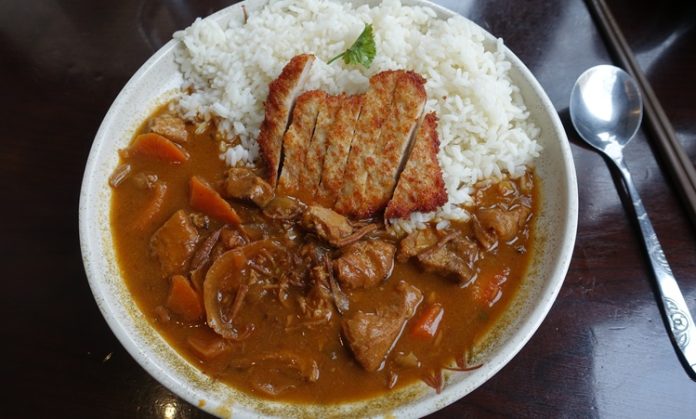 Katsu Curry, Japon mutfağının hem geleneksel hem de modern dokunuşlarını bir arada sunan özel bir yemektir. “Katsu” kelimesi çıtır kaplamalı kızarmış et kotletini ifade ederken, “curry” Japonya’ya 19. yüzyılda İngilizler aracılığıyla Hindistan’dan gelen köri baharat karışımını anlatır. Bu iki farklı unsurun birleşmesiyle ortaya çıkan yemek, Japonya’da kısa sürede popülerlik kazanmıştır. Konulu bir haber görseli.