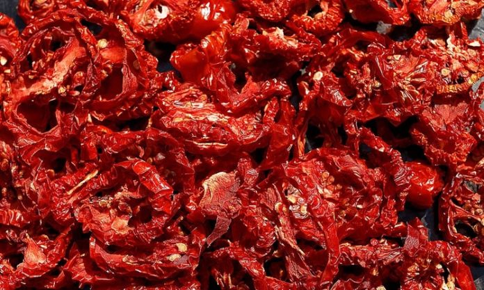 Kurutulmuş domates, mutfaklarda giderek daha fazla tercih edilen sağlıklı ve doğal ürünlerden biridir. Taze domateslerin özel yöntemlerle suyunun çekilmesi ve güneşte ya da düşük sıcaklıkta kurutulmasıyla elde edilir. Böylece domatesin besin değerleri korunur, aroması yoğunlaşır ve daha uzun süre saklanabilir hale gelir. Doğal yapısı sayesinde hem geleneksel hem de modern tariflerde kullanılabilen kurutulmuş domates, sofralara farklı bir tat ve zenginlik katar. Konulu bir haber görseli.