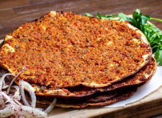 Lahmacun: Türk Mutfağının İnce Hamur Üzerindeki Efsane Lezzeti Türk mutfağının en sevilen lezzetlerinden biri olan lahmacun, yüzyıllardır sofralarda kendine yer bulmaktadır. İnce açılmış hamurun üzerine kıyma, domates, soğan, maydanoz ve çeşitli baharatlarla hazırlanan iç harcın eklenmesiyle pişirilen bu eşsiz yemek, hem lezzeti hem de pratikliğiyle öne çıkar. Anadolu’nun farklı bölgelerinde yaygın olarak tüketilen lahmacun, özellikle Güneydoğu mutfağının vazgeçilmezleri arasında yer almaktadır. Konulu bir haber görseli.
