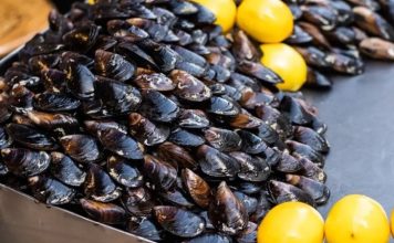 Midye Dolma: Denizden Sofralara Lezzetli Atıştırmalık Midye dolma, taze midyelerin pirinç, soğan, baharat ve bazen etle doldurularak hazırlanan geleneksel bir deniz ürünü yemeğidir. Özellikle Karadeniz ve Ege mutfağında sıkça rastlanan bu lezzet, hem sokak lezzeti hem de ev yemeği olarak tüketilmektedir. Midyenin doğal tuzluluğu ve dolgun iç harcı, yemeğe kendine has bir aroma katar. Konulu bir haber görseli.