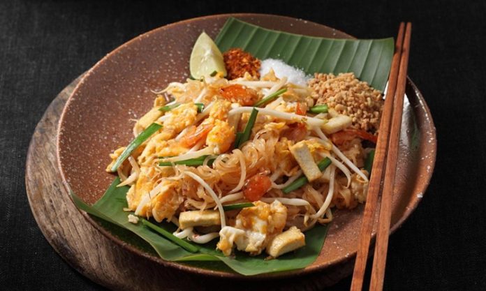 Pad Thai, Tayland mutfağının en bilinen yemeklerinden biridir ve dünya genelinde milyonlarca insan tarafından sevilerek tüketilmektedir. Bu yemek, özellikle Tayland’ın kimliğini yansıtan bir lezzet olarak öne çıkar. 1930’lu yıllarda ülkenin milli kimliğini güçlendirmek amacıyla öne çıkarılan bu yemek, kısa sürede Tayland’ın ulusal yemeklerinden biri haline gelmiştir. Pirinç eriştesiyle yapılan bu özel yemek, Tayland’ın zengin mutfak kültürünü uluslararası alanda temsil etmektedir. Konulu bir haber görseli.