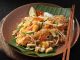 Pad Thai, Tayland mutfağının en bilinen yemeklerinden biridir ve dünya genelinde milyonlarca insan tarafından sevilerek tüketilmektedir. Bu yemek, özellikle Tayland’ın kimliğini yansıtan bir lezzet olarak öne çıkar. 1930’lu yıllarda ülkenin milli kimliğini güçlendirmek amacıyla öne çıkarılan bu yemek, kısa sürede Tayland’ın ulusal yemeklerinden biri haline gelmiştir. Pirinç eriştesiyle yapılan bu özel yemek, Tayland’ın zengin mutfak kültürünü uluslararası alanda temsil etmektedir. Konulu bir haber görseli.