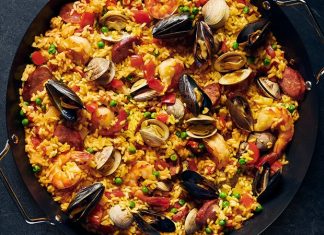 Paella İspanya Mutfağının Renkli Lezzeti Paella, İspanya’nın en bilinen yemeklerinden biri olarak dünya mutfağında önemli bir yere sahiptir. Özellikle Valencia bölgesinde ortaya çıkan bu yemek, zamanla tüm ülkeye ve oradan da dünyaya yayılmıştır. Tarihi 15. yüzyıla kadar uzanan paella, köylülerin tarlalarda buldukları malzemeleri bir araya getirerek pişirdikleri pratik bir yemek olarak doğmuştur. Konulu bir haber görseli.