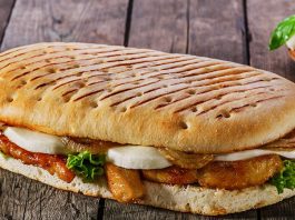 Panini: İtalyan Lezzetinin Hızlı Atıştırması Panini, İtalyan mutfağının en sevilen ve hızlı atıştırmalık seçeneklerinden biridir. Kelime anlamı olarak “küçük ekmekler” anlamına gelen panini, İtalya’da özellikle öğle yemeklerinde tercih edilir. Geleneksel olarak ciabatta veya focaccia ekmeği kullanılarak hazırlanan panini, peynir, et ve sebzelerle zenginleştirilir. Konulu bir haber görseli.