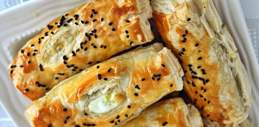 Peynirli börek, Türk mutfağının en özel ve geleneksel lezzetlerinden biridir. Çay saatlerinin en çok aranan eşlikçisi, misafir sofralarının baş tacı ve sabah kahvaltılarının olmazsa olmazı olan bu börek çeşidi, pratik hazırlanışıyla da gönülleri fetheder. Kat kat yufkaların arasına serilen lezzetli peynir harcı sayesinde ortaya çıkan doyurucu tat, hem günlük öğünlerde hem de özel davetlerde sıklıkla tercih edilir. Bugün, peynirli böreğin tarihinden yapılışına, farklı çeşitlerinden püf noktalarına kadar pek çok detayı keşfedeceğiz. Konulu bir haber görseli.