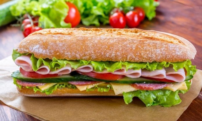 Salamlı sandviç, hızlı ve pratik öğün arayanların tercih ettiği klasik bir seçenek olarak öne çıkar. İlk kez Avrupa mutfaklarında popülerleşen bu sandviç, salamın ince dilimlenmiş haliyle ekmek arasına yerleştirilmesiyle hazırlanır. Geleneksel tarif, sadece salam ve ekmekle yapılırken zamanla peynir, marul ve domates gibi ek malzemelerle zenginleştirilmiştir. Konulu bir haber görseli.