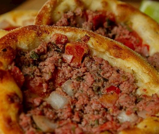 Sfiha, Ortadoğu mutfağının kendine has hamur işleri arasında öne çıkan bir lezzettir. İnce açılmış hamurun üzerine kıyma, soğan, baharat ve bazen sebze ile hazırlanan sfiha, hem atıştırmalık hem de ana öğün olarak tercih edilir. Özellikle Lübnan, Suriye ve Türkiye’nin bazı bölgelerinde geleneksel olarak tüketilen bu lezzet, şehir mutfaklarında da popülerliğini koruyor. Konulu bir haber görseli.