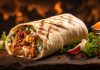 Orta Doğu mutfağının en bilinen sokak lezzetlerinden biri olan Shawarma, ince dilimlenmiş etin özel baharatlarla marine edilip dikey döner üzerinde pişirilmesiyle hazırlanır. Genellikle tavuk, dana veya kuzu eti kullanılır ve lavaş veya pita ekmeğiyle servis edilir. Bu lezzet, hem hızlı hem de doyurucu bir öğün alternatifi sunar. Konulu bir haber görseli.