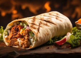 Orta Doğu mutfağının en bilinen sokak lezzetlerinden biri olan Shawarma, ince dilimlenmiş etin özel baharatlarla marine edilip dikey döner üzerinde pişirilmesiyle hazırlanır. Genellikle tavuk, dana veya kuzu eti kullanılır ve lavaş veya pita ekmeğiyle servis edilir. Bu lezzet, hem hızlı hem de doyurucu bir öğün alternatifi sunar. Konulu bir haber görseli.