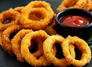 Soğan Halkası: Atıştırmalık Lezzetlerin Vazgeçilmezi Soğan halkası, fast food kültürünün en sevilen atıştırmalıklarından biri olarak öne çıkıyor. Tarihi 20. yüzyılın ortalarına dayanan bu lezzet, özellikle Amerika’da popülerlik kazanmış ve kısa sürede dünya mutfaklarına yayılmıştır. Patates kızartmaları ve burgerlerin yanında ikincil lezzet olarak sunulan soğan halkaları, hem çıtır dokusu hem de tatlımsı soğan aroması ile dikkat çekiyor. Konulu bir haber görseli.