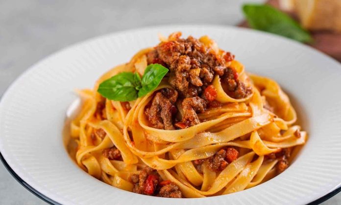 Tagliatelle, İtalyan mutfağının en tanınmış makarna çeşitlerinden biri olarak bilinir. Genellikle geniş ve uzun şeritler halinde hazırlanır. Bu makarna türü, özellikle Bolognese sosu ile eşsiz bir uyum yakalar ve İtalya’nın Emilia-Romagna bölgesinde köklü bir geçmişe sahiptir. Konulu bir haber görseli.
