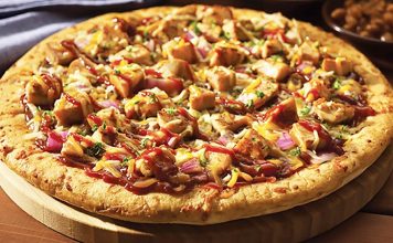 Tavuklu Pizza: Lezzetli ve Pratik Bir Seçenek Tavuklu Pizza Tarihi Ve Kökeni Tavuklu pizza, klasik İtalyan pizzalarından türeyen modern ve lezzetli bir alternatiftir. Tavuk etinin pizzaya eklenmesi, hem protein açısından zengin bir öğün sunar hem de farklı tat kombinasyonları yaratır. İlk olarak Amerika’da popüler hale gelen tavuklu pizza, günümüzde dünya genelinde restoran menülerinde sıkça yer alıyor. Tavuklu pizzanın popülerliği, özellikle hızlı ve dengeli bir öğün arayanlar için idealdir. Restoranlar ve ev mutfaklarında hazırlanan bu pizza, taze malzemelerle birleştiğinde hem göze hem damağa hitap eder. Tavuk, pizza kültürüne yenilik katan bir unsur olarak öne çıkar. Tavuklu Pizza Malzemeleri Ve Hazırlık Süreci Evde veya restoranlarda yapılan tavuklu pizza, hamur, domates sosu, peynir ve tavuk eti ile hazırlanır. Tavuk parçaları, önceden marine edilip sotelenerek pizzaya eklenebilir. Bu işlem, tavuğun hem lezzetini artırır hem de yumuşak bir doku sağlar. Pizzada kullanılan sebzeler de lezzeti tamamlar. Biber, mantar, soğan veya mısır gibi malzemeler tavukla uyum sağlar. Mozzarella veya cheddar peyniri, tavuk ve sebzelerle birleşerek zengin bir tat deneyimi sunar. Hamurun kabarması ve fırın sıcaklığı, pizzanın çıtır ve lezzetli olmasında kritik rol oynar. Restoranlarda Tavuklu Pizza Deneyimi Profesyonel mutfaklarda tavuklu pizza, hem görsellik hem de lezzet açısından özenle hazırlanır. Tavuk parçaları eşit dağıtılarak pizzaya eklenir ve fırınlanır. Fırın sıcaklığı, tavuk etinin kurumasını engeller ve pizza hamurunun ideal dokuda olmasını sağlar. Bazı restoranlar tavuklu pizzayı baharatlı soslarla veya farklı peynir çeşitleriyle sunarak özgün tatlar yaratır. Bu sayede pizza, klasik lezzetinden ayrılarak daha sofistike bir hale gelir. Tavuklu pizza, hem hızlı hem de doyurucu bir öğün alternatifi olarak öne çıkar. Evde Tavuklu Pizza Yapmanın Püf Noktaları Evde yapılan tavuklu pizza, malzeme seçimi ve hazırlık süreci ile fark yaratır. Hamur ne çok ince ne de çok kalın olmalıdır; bu denge pizzanın dokusunu belirler. Tavuk etinin önceden marine edilmesi ve uygun şekilde pişirilmesi, pizzanın lezzetini artırır. Sebzeler ve peynir, tavukla uyumlu şekilde eklenmelidir. Mozzarella peyniri, tavuk parçalarının üzerinde eriyerek hem lezzet hem de görsellik sağlar. Fırın sıcaklığı genellikle 220-250 derece arasında olmalı ve pişirme süresi hamurun kalınlığına göre ayarlanmalıdır. Tavuklu Pizza Çeşitleri Tavuklu pizza, malzeme kombinasyonuna göre farklılık gösterir. Barbekü soslu, acılı tavuklu, mantarlı ve sebzeli seçenekleri bulunur. Bu çeşitler pizzayı hem lezzet hem de besin değeri açısından zenginleştirir. Diyet tercihlerine göre glutensiz hamur veya az yağlı peynir kullanarak evde tavuklu pizza hazırlamak mümkündür. Bu alternatifler, sağlıklı beslenme alışkanlığına önem verenler için idealdir. Tavuklu pizza, hem klasik hem de modern damak zevklerine hitap eder. Tavuklu Pizza Sağlık Açısından Temel malzemeleri tavuk ve sebzeler olan tavuklu pizza, dengeli bir öğün alternatifi oluşturur. Tavuk eti protein açısından zengindir ve kas gelişimini destekler. Sebzeler ise vitamin, mineral ve lif sağlar. Peynirler de kalsiyum ve protein içererek öğünü tamamlar. Evde yapılan tavuklu pizzada yağ ve tuz miktarının kontrol edilmesi, daha sağlıklı bir seçenek sunar. Taze sebzeler ve kaliteli tavuk kullanımı, pizzayı hem lezzetli hem de besleyici bir öğün haline getirir. Tavuklu Pizza Kültürü ve Popülerliği Tavuklu pizza, dünya genelinde pizza kültürünün modern ve sağlıklı alternatiflerinden biri olarak öne çıkıyor. Restoranlardan ev mutfaklarına kadar her yerde bulunabilir. Tavuklu pizzanın popülerliği, hem hızlı hem de doyurucu bir öğün arayanlar için vazgeçilmez bir seçenek olmasını sağlıyor. Restoran zincirlerinden butik pizzacılara kadar pek çok yerde sunulan tavuklu pizza, klasik pizza türleri arasında kendine özel bir yer edinmiştir. Tavuk etinin ve malzemelerin tazeliği, pizzayı her yaştan tüketici için cazip kılar ve pizza kültürünü daha zengin bir hale getirir. Konulu bir haber görseli.