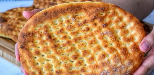 Tırnak Pide: Gelenekten Günümüze Uzanan Lezzet Türk mutfağının en sevilen ekmek çeşitlerinden biri olan tırnak pide, özellikle Ramazan sofralarının ve kebapçıların vazgeçilmez lezzetleri arasında yer alır. Yumuşak içi ve hafif çıtır kabuğu ile öne çıkan bu pide, hem sade olarak hem de farklı yemeklerin eşlikçisi şeklinde tüketilir. Tırnak pide, adını hamura parmak uçlarıyla yapılan tırnak izlerinden alır ve bu izler pişirme sırasında pideye özgün bir görünüm kazandırır. Hem görselliği hem de tadıyla sofraları süsleyen bu geleneksel lezzet, Anadolu’nun mutfak kültüründe önemli bir yere sahiptir. Konulu bir haber görseli.