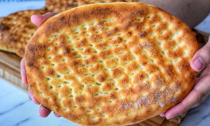 Türk mutfağının en sevilen ekmek çeşitlerinden biri olan tırnak pide, özellikle Ramazan sofralarının ve kebapçıların vazgeçilmez lezzetleri arasında yer alır. Yumuşak içi ve hafif çıtır kabuğu ile öne çıkan bu pide, hem sade olarak hem de farklı yemeklerin eşlikçisi şeklinde tüketilir. Tırnak pide, adını hamura parmak uçlarıyla yapılan tırnak izlerinden alır ve bu izler pişirme sırasında pideye özgün bir görünüm kazandırır. Hem görselliği hem de tadıyla sofraları süsleyen bu geleneksel lezzet, Anadolu’nun mutfak kültüründe önemli bir yere sahiptir. Konulu bir haber görseli.