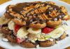 Waffle, Belçika kökenli, çıtır dışı ve yumuşak içi ile bilinen tatlı hamur ürünüdür. Orta Çağ’dan bu yana Avrupa’da tüketilen bu lezzet, zamanla Amerika ve diğer kıtalara yayılmıştır. Geleneksel olarak kahvaltıda veya tatlı saatlerinde tercih edilen waffle, taze meyve, çikolata veya karamel sosla servis edilir. Konulu bir haber görseli.