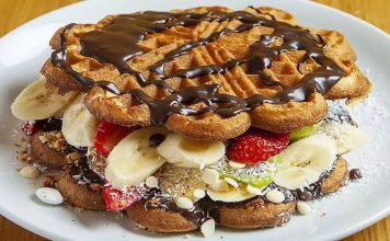Waffle: Tatlı Severlerin Vazgeçilmez Lezzeti Waffle, Belçika kökenli, çıtır dışı ve yumuşak içi ile bilinen tatlı hamur ürünüdür. Orta Çağ’dan bu yana Avrupa’da tüketilen bu lezzet, zamanla Amerika ve diğer kıtalara yayılmıştır. Geleneksel olarak kahvaltıda veya tatlı saatlerinde tercih edilen waffle, taze meyve, çikolata veya karamel sosla servis edilir. Konulu bir haber görseli.
