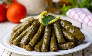 Yaprak Sarma: Geleneksel Lezzetin Sofralardaki Vazgeçilmezi Türk mutfağının en köklü lezzetlerinden biri olan yaprak sarma, tarih boyunca hem sofraları hem de kültürü zenginleştiren bir yemek olarak bilinir. Osmanlı döneminden günümüze uzanan bu gelenek, özellikle özel günlerde ve davet sofralarında kendine yer bulur. Yaprak sarmanın hazırlanışı ve sunumu, mutfak kültürümüzün inceliklerini gösterir ve aile bağlarını güçlendiren bir unsur olarak öne çıkar. Konulu bir haber görseli.