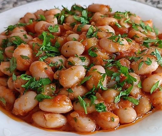 Zeytinyağlı barbunya, Türk mutfağının klasik ve sağlıklı yemeklerinden biridir. Özellikle yaz ve bahar aylarında sofraları süsleyen bu lezzet, Ege ve Marmara bölgelerinde sıkça hazırlanır. Barbunya fasulyesi, protein ve lif açısından zengin bir baklagil olup, zeytinyağı ile birleştiğinde hem hafif hem de besleyici bir öğün sunar. Konulu bir haber görseli.