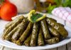 Zeytinyağlı yaprak sarma, Türk mutfağının en sevilen geleneksel lezzetlerinden biridir. Özellikle meze olarak sofralarda sıkça yer alır ve hem hafif hem de besleyici bir alternatif sunar. Yaprak sarması, sadece Türkiye’de değil, Orta Doğu ve Balkan mutfaklarında da farklı yorumlarla hazırlanır. Konulu bir haber görseli.